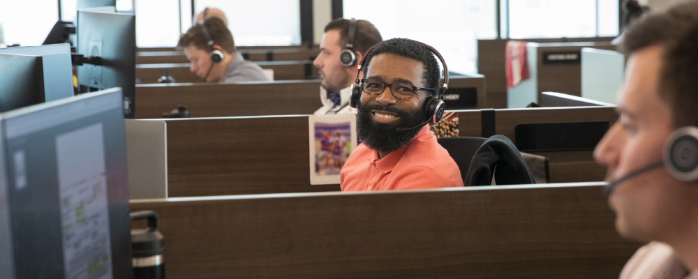 man with headset smiling at camera